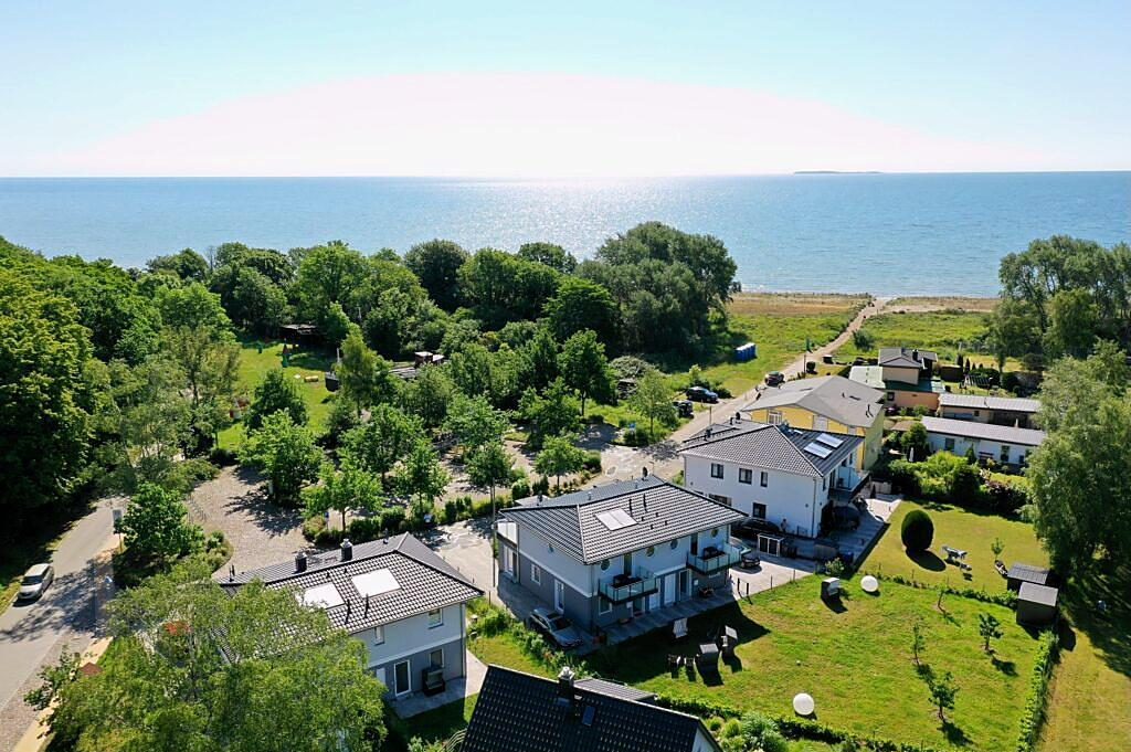 Luftaufnahme: die Sealodge mit Garten, dahinter Wald und die Ostsee