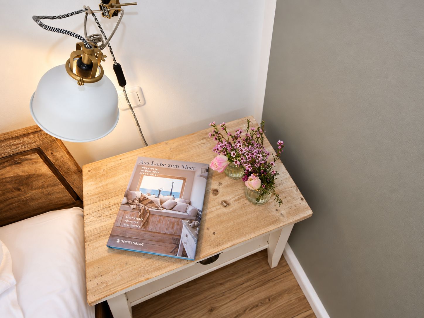 Nachttisch mit Blumen und Buch