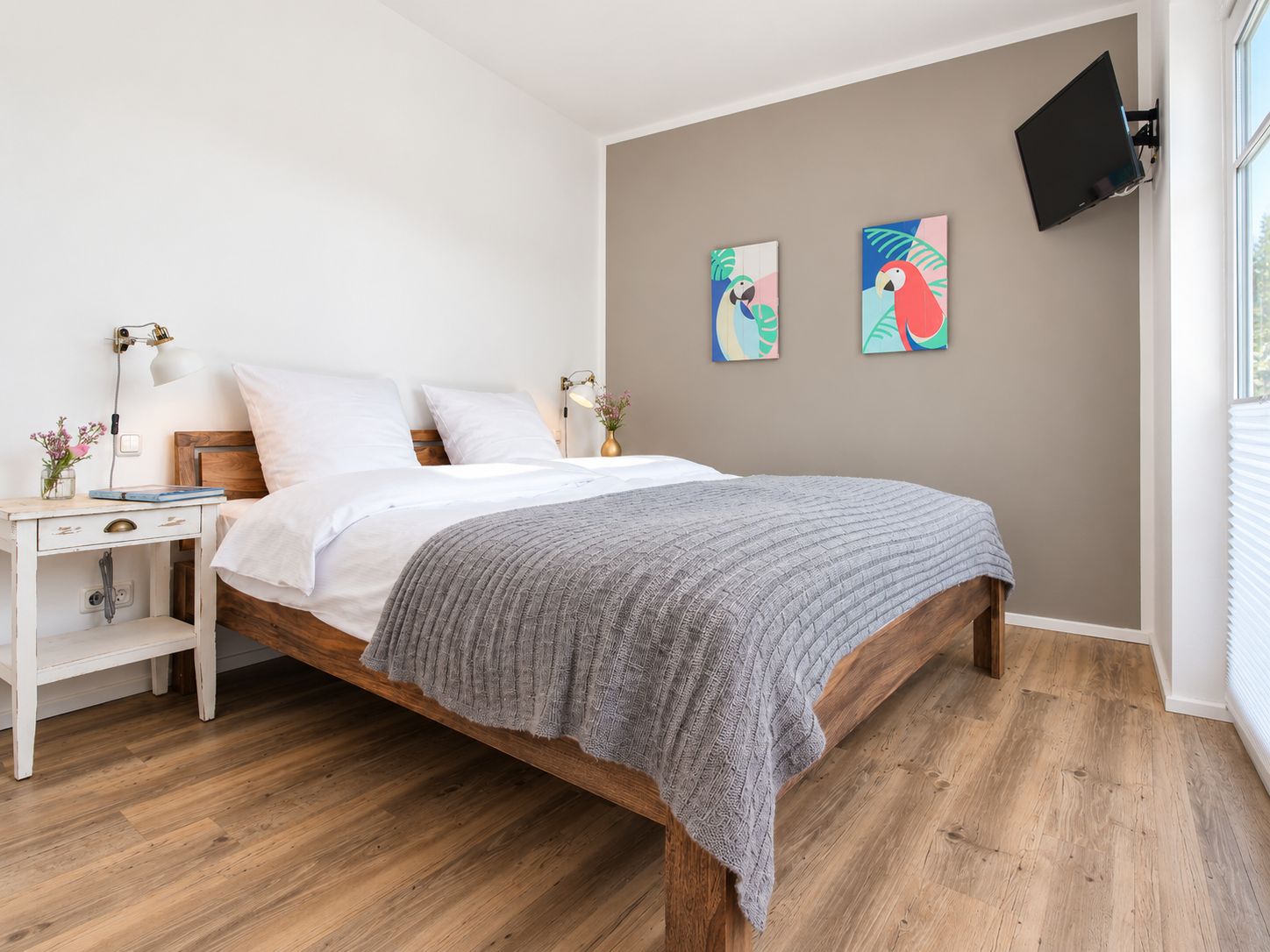 Schlafzimmer mit Holzbett und Fenster